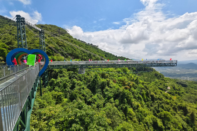 Прогулка по стеклянному мосту Хайнаня в облаках